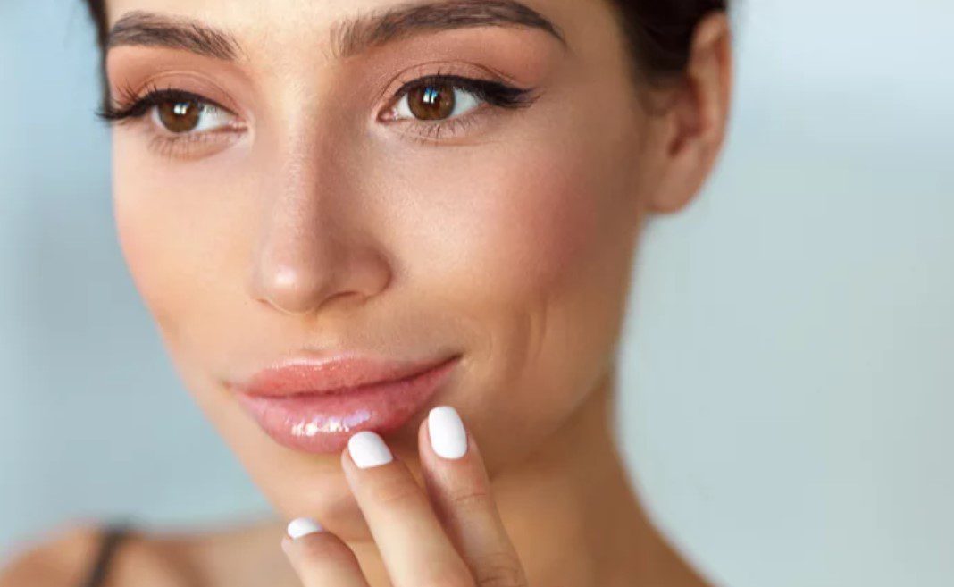 A woman with white nails and pink lips