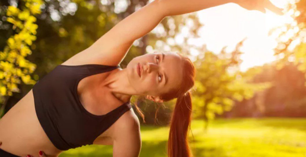 A woman is stretching in the park